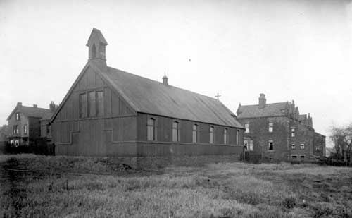 St. Paulinus district church in the Parkside area of Dewsbury Road, situated by the junction with Westland Road. The rears of semi-detached houses facing on to Dewsbury Road are seen on the right while on the left are houses on Cross Flatts Grove. The church was shortly to be demolished and is now the site of The Broadway public house. Pictured in December 1929.