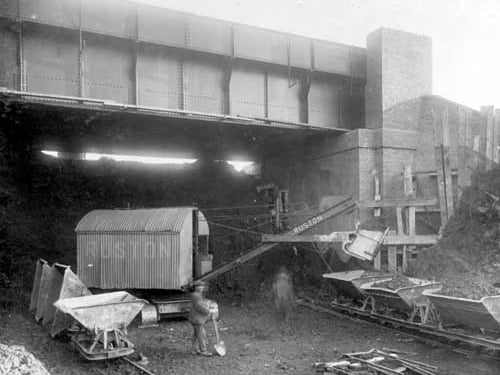 A view of a newly built bridge on Beeston Ring Road. A mechanical shovel is filling trucks with debris from the site. Pictured in December 1928.