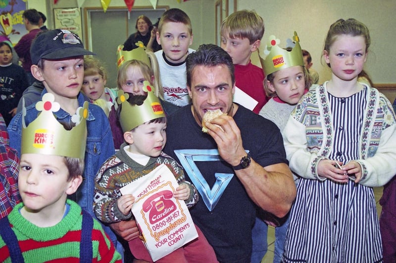 Three year old Scott Merchant from Houghton sat on the knee of Gladiator Trojan while he tucked into a burger at the Granada Service Station in Washington in 1994.