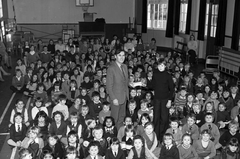 Tollcross Primary School pupils hand over a cheque for  150, made from a sponsored spelling bee in November 1974.