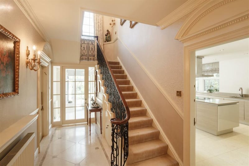 A grand staircase leads to the upper floor where bedrooms can be found.
