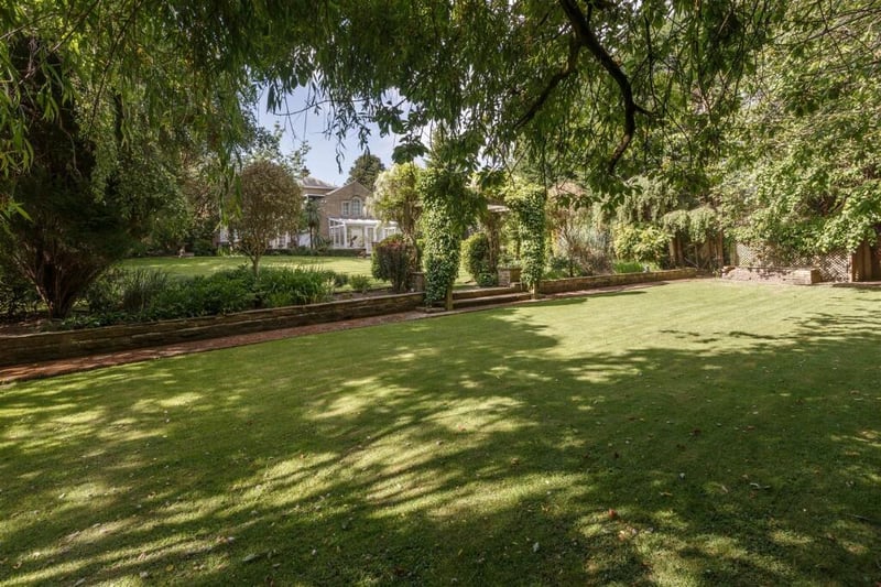 Large lawns, planted borders and mature trees and shrubs complete this delightful garden.