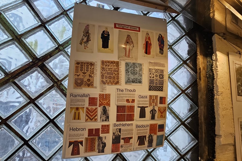 Located by the stair set, the information board explains the unique patterns and colours used in dresses in different sections of Palestine.
