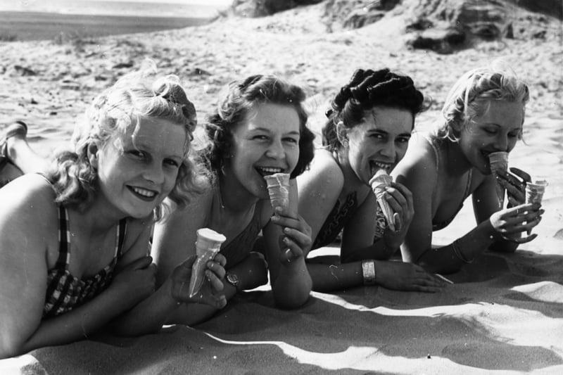 3rd June 1939:  Girls on the beach at Blackpool, Lancashire, enjoying their ice-creams