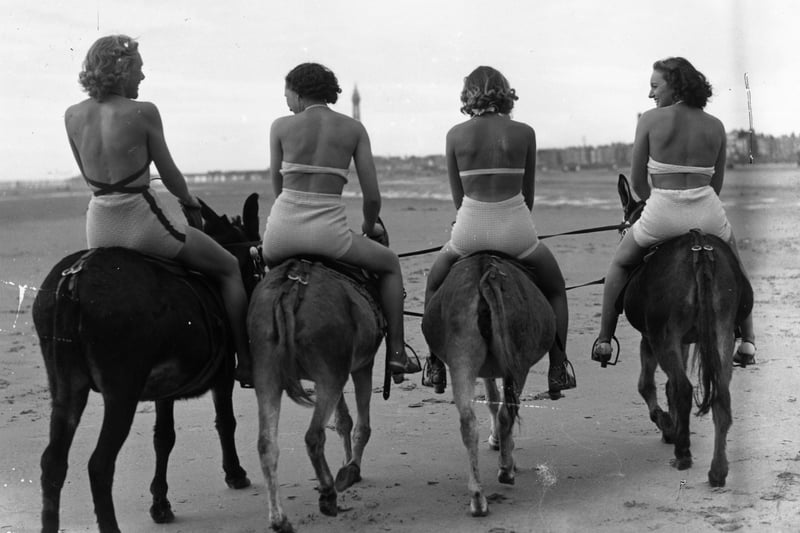 18th April 1938:  Four bathers on a donkey ride on Blackpool beach at Easter