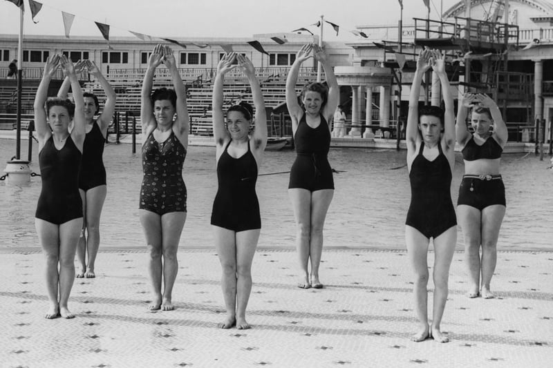 French women footballers in swimwear stretching during an exercise session in a swimming pool at Blackpool, Lancashire, England, 2nd July 1938