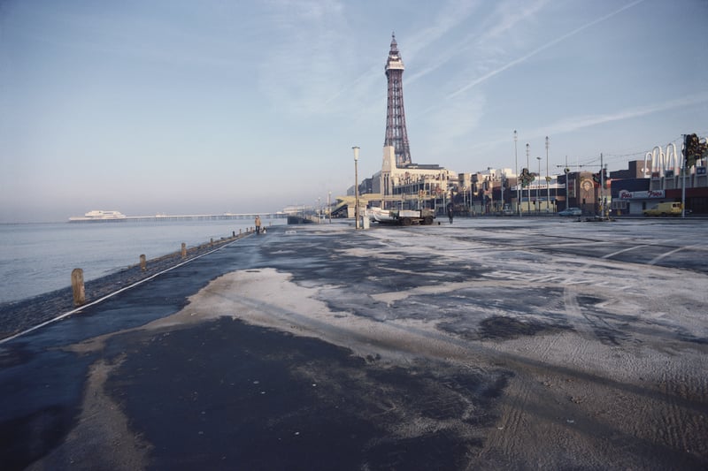 A couple of dog walkers in an otherwise deserted seafront in the seaside town of Blackpool, Lancashire, England, December 1982