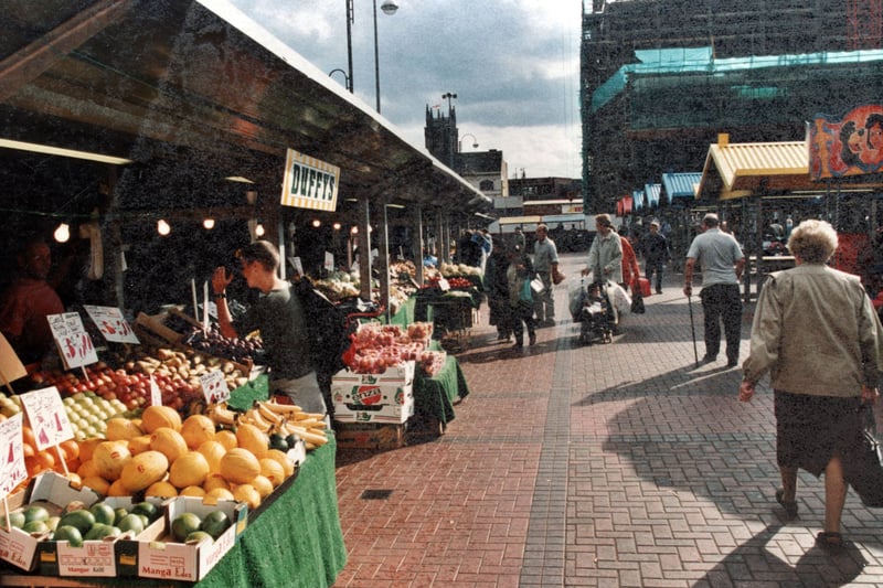 Looking along the row of vegetable stalls towards New York Street, we see in the distance Leeds Parish Church and the new multi-storey carpark under construction. Pictured in September 1999.