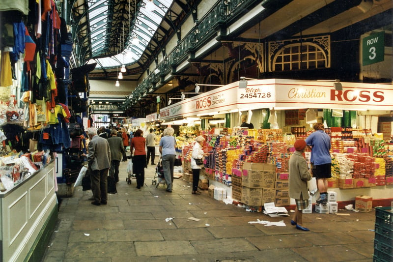 Inside Kirkgate Market Hall in September 1999. A Children's Clothes stall is on the left with Christian Ross Confectioners on the right.