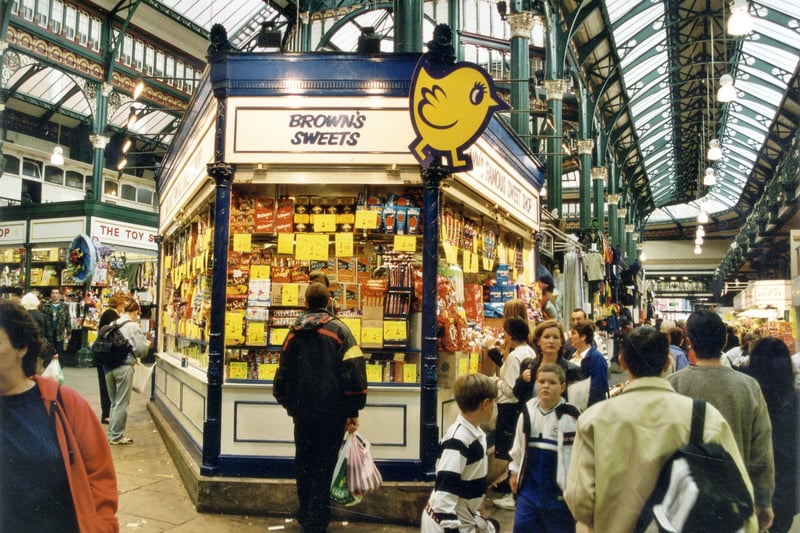 Sshoppers and stalls in Kirkgate Market Hall in September 1999. Brown's Sweet stall is in the centre of the photo with The Toy Stall visible in the background.