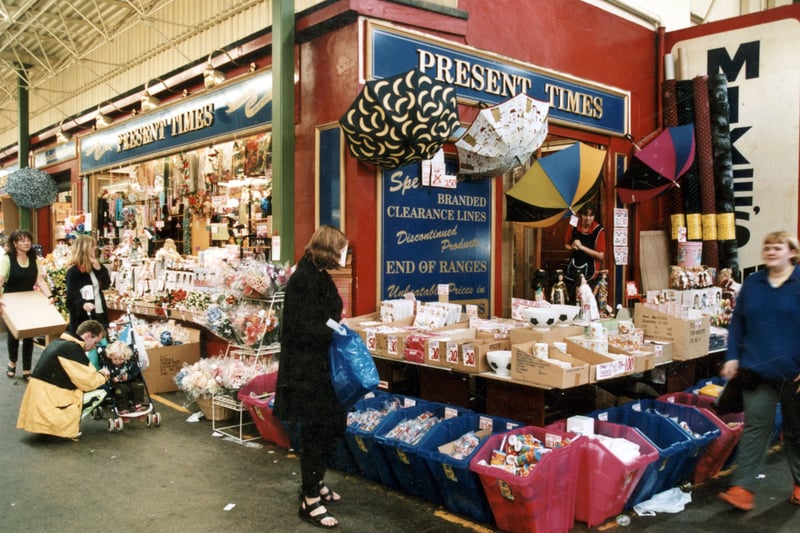 Discount shop Present Times in September 1999. To the left, a stall worker carries a box to the display at the front of the shop.