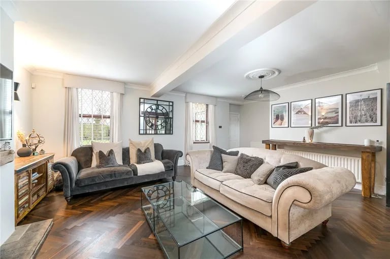 The spacious room, which also hosts stairs to the first floor, has windows overlooking the front elevation as well as a feature fireplace.