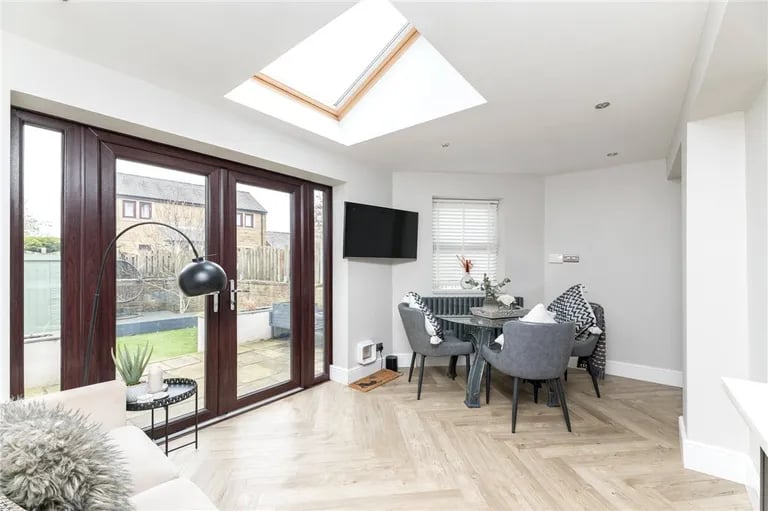 While the dining area is bright and airy with skylight and French doors onto the rear garden.