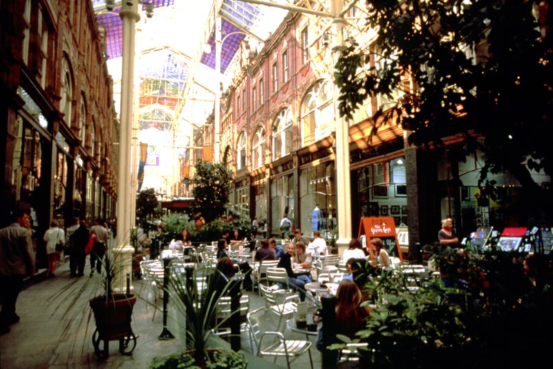 The Victoria Quarter showing the stained glass roof by Brian Clarke dating from May 1990. This was formerly Queen Victoria Street and is now a wide arcade of upmarket retail estalishments with the former Cross and County arcades intersecting. 'The Street Cafe' is part of the Harvey Nichols department store which opened in Leeds in 1996.