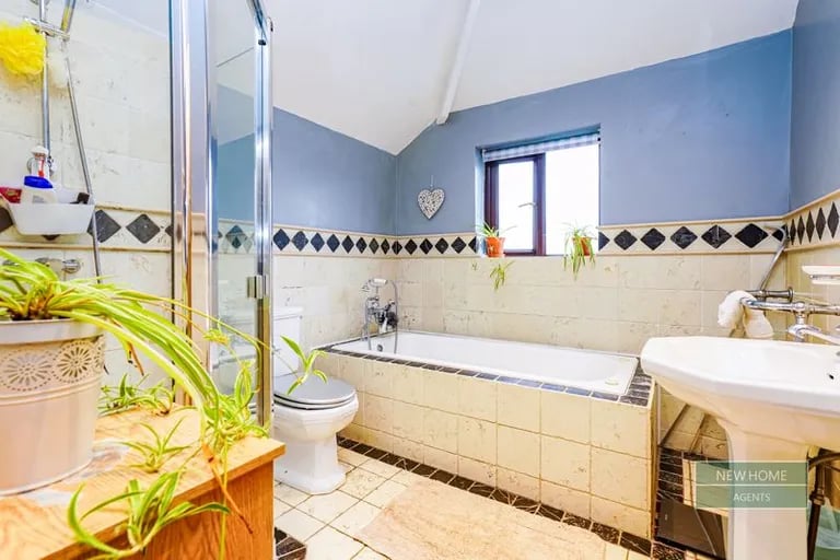 The stylish family bathroom benefits from a bathtub and separate shower.