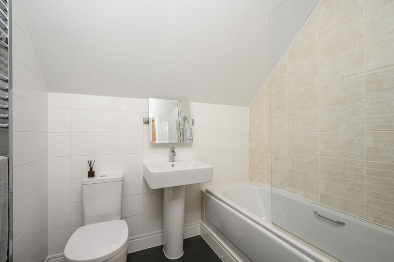 The family bathroom with white suite and electric over bath shower.