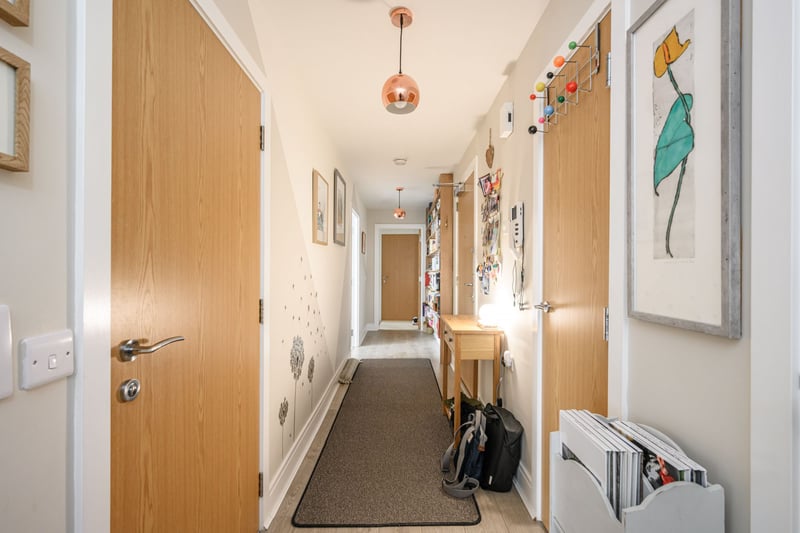 The entrance hallway with secure entryphone system and useful built-in storage including two large utility closets, one plumbed with the washing machine. 
