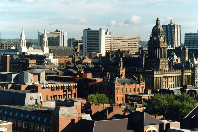 An aerial view looking across rooftops to the Town Hall, on the right, and the Civic Hall, further back on the left. The tall white building in between is Leeds College of Technology with Merrion House behind this. The tallest building in the background on the right is Tower House. Behind the Civic Hall are buildings of Leeds Metropolitan University. Nearer the foreground, alongside the Town Hall on The Headrow/Westgate are Oxford Place Chapel, centre, and the Combined Court, left.