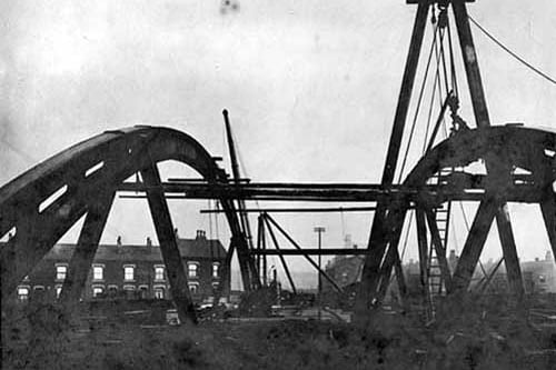 Looking from Hunslet to Cross Green, over the old bridge. Steam cranes are being used to dismantle the bridge structure. Pictured in January 1899.