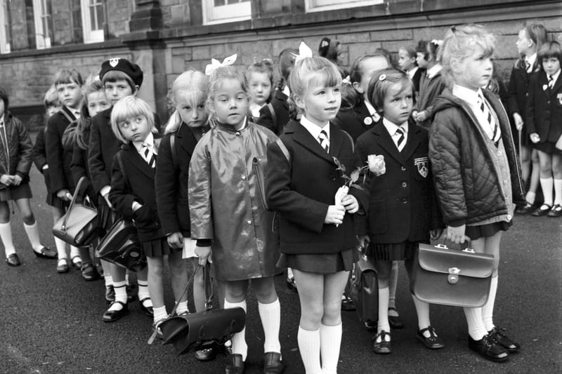 Girls wait in the playground on their first day at Flora Stevenson primary school in Edinburgh in August 1970. Rosemary Holden, in front, has a rose for her new teacher.