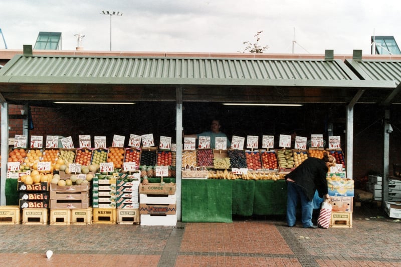 A fruit stall on the outdoor Kirkgate Market. A row of fruit for sale with the stallholder stood behind. Pictured in September 1999.