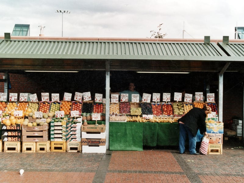 A fruit stall on the outdoor Kirkgate Market. A row of fruit for sale with the stallholder stood behind. Pictured in September 1999.