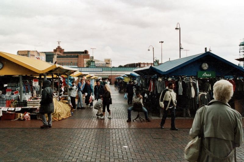 This photo of the outdoor market was taken from just outside the doors of the indoor market and shows a row of stalls leading down to the City Bus Station. In the distance can be seen the Leeds College of Music and Quarry House. Pictured in September 1999.