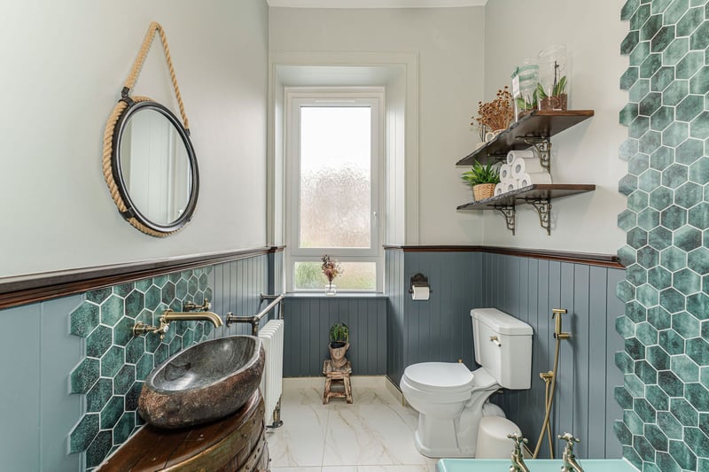 The upgraded bathroom suite with unique features that include an original cast iron bath, handmade tiles, handcrafted barrel vanity and stone basin. 