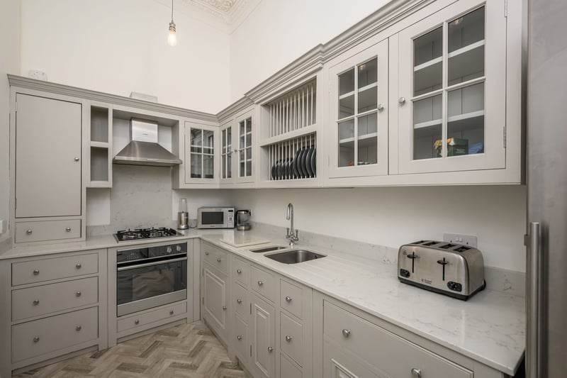 The kitchen is fitted with a variety of stylish high spec units, with sleek coordinated worktops, herringbone flooring and a range of integrated appliances.
