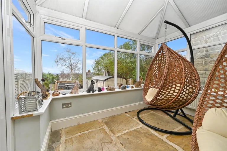 The sun room can be reached via the kitchen and overlooks the sprawling garden.