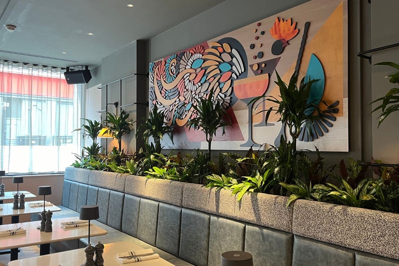 The interior design of Social Bird includes greenery and chicken-inspired artwork.