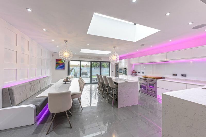 The open plan kitchen has integrated appliances throughout with granite worktops and bi-folding doors, which lead to the raised rear terrace.