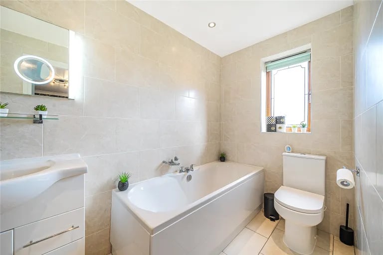 The fully tiled en-suite has a bath and separate shower.