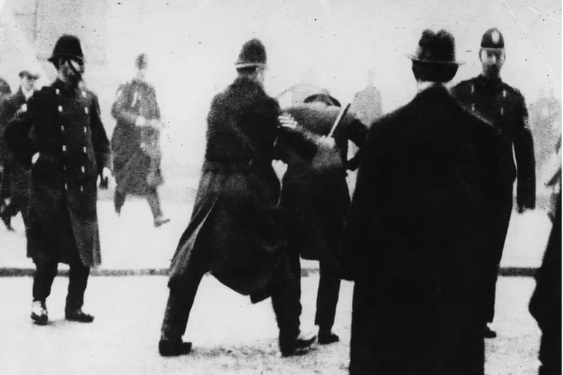Police strike a restrained protestor during the Battle of George Square in 1919.