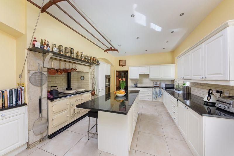 The kitchen comes complete with granite work surfaces, integrated appliances, an oil-fired Aga and a central island breakfast bar.