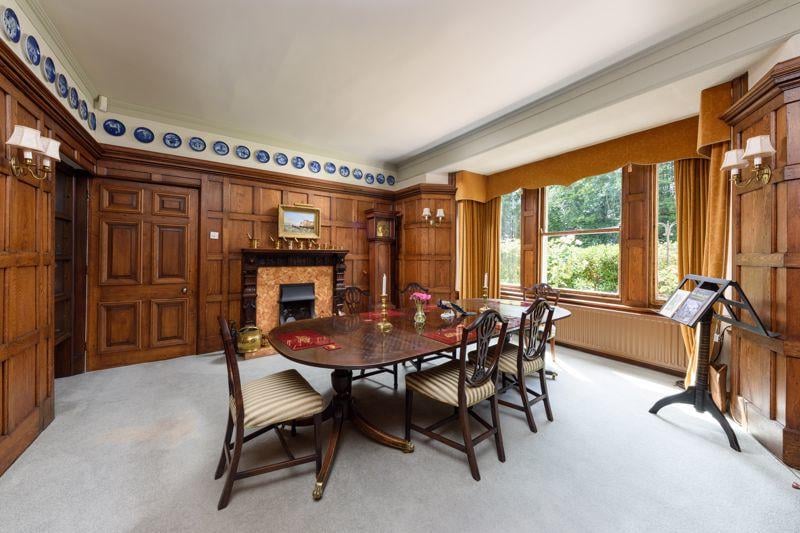 The formal dining room features panelled walls, a period fireplace and a big window, which lets in plenty of natural light.