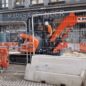 Contractor operating a mini-digger outside Fargate.