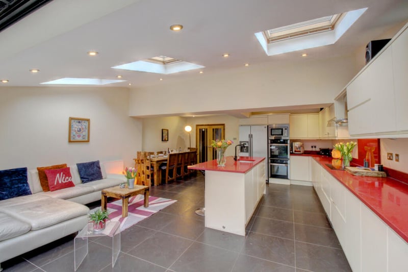 Here is a stylish kitchen with central island, bi-folding glass doors onto the rear garden patio and plenty of space for dining tables and furniture.