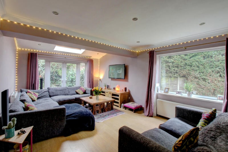 The spacious lounge has been extended to feature a skylight and French doors leading onto the garden.
