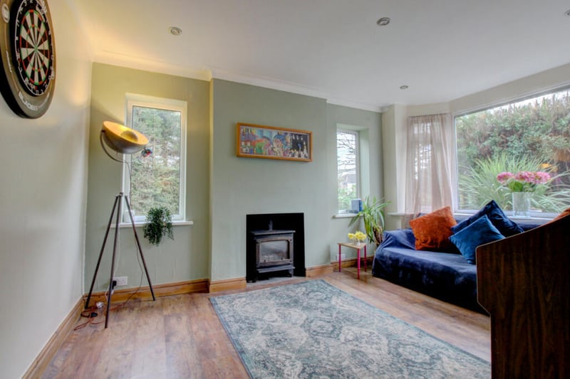 The second reception room features a charming bay window overlooking the front garden and a log burner.
