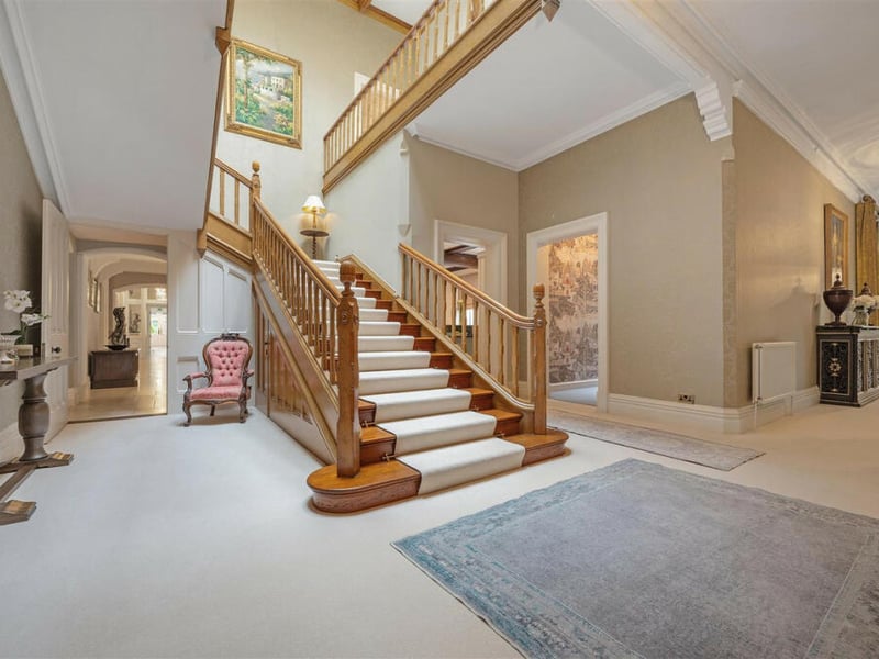 A mezzanine level overlooking a sweeping staircase is an elegant feature