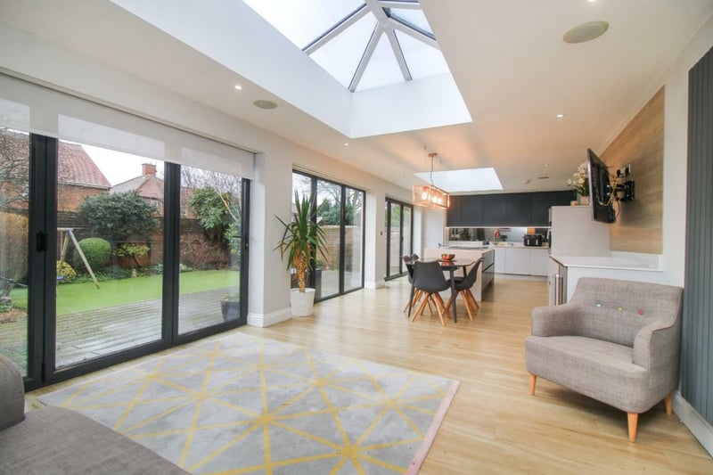 The property's kitchen/dining area is open plan and well lit, with three sets of bi-fold doors two sky lights.