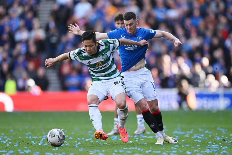 Celtic midfielder Tomoki Iwata attempts to shield the ball from Rangers' Tom Lawrence during a lively start to the match.