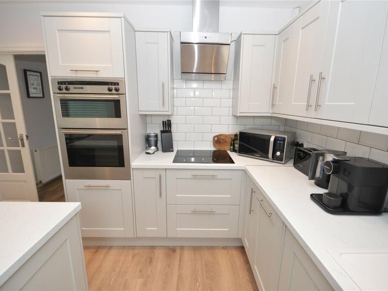 Here is a breakfast bar along with a range of integrated appliances and base and wall units.