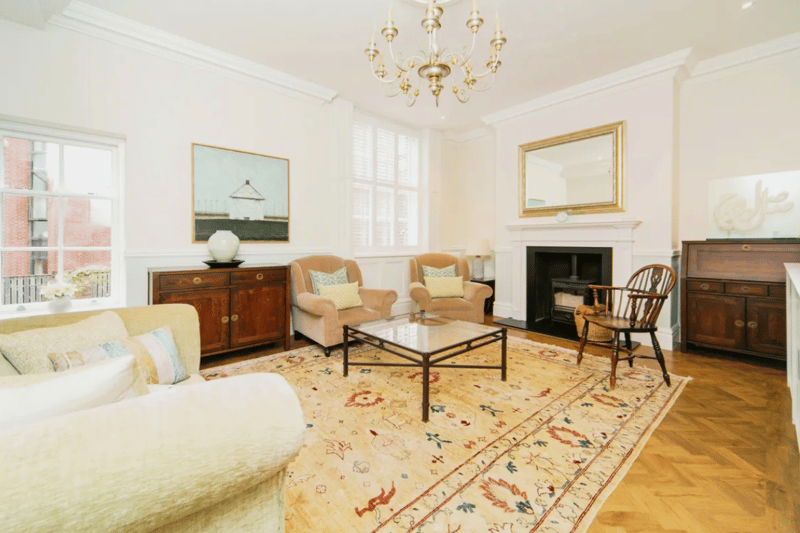 Expansive reception space to rear of home with double sash windows and fireplace.