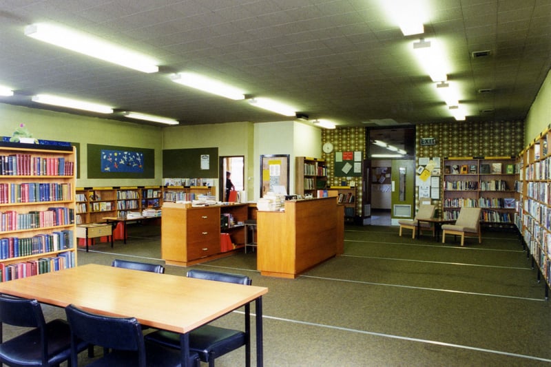Inside Drighlington Branch Library on Moorland Road. The counter is in the middle of the room with bookshelves around the walls.