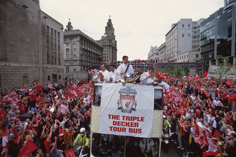 The Liverpool tour bus moves through crowds of fans on its parade to display the team's three trophies, the UEFA Cup, Worthington Cup and FA Cup, through the streets of Liverpool - May 2001.