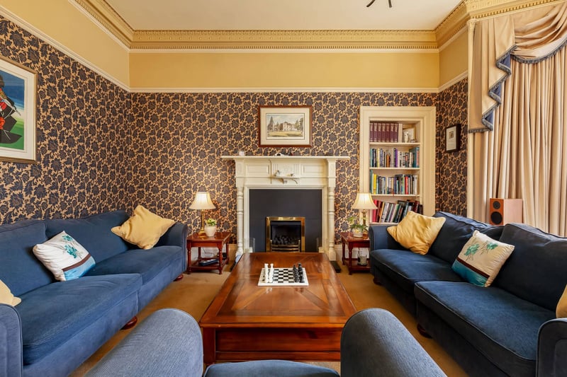 The south-facing sitting room with timber mantel piece and bay window with views to the front of the property.