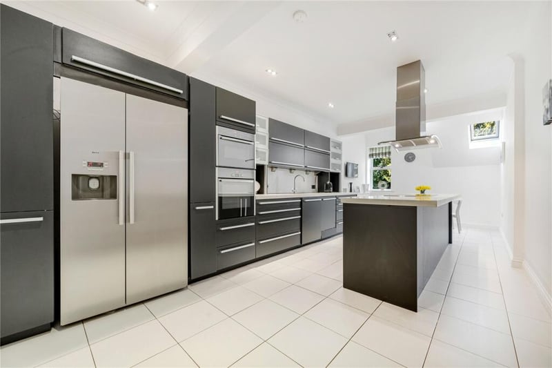 The kitchen is equipped with modern brand appliances complemented by sleek Corian worktops for both style and functionality. 