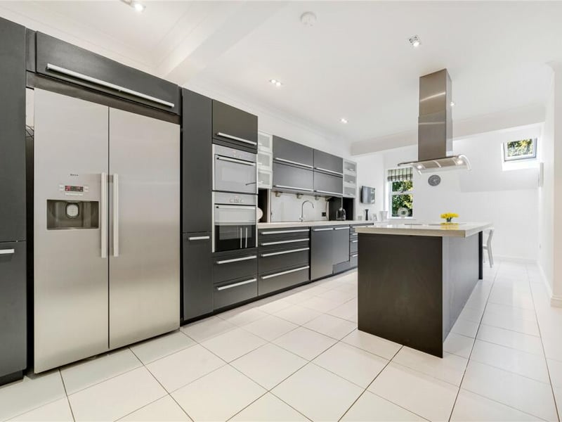 The kitchen is equipped with modern brand appliances complemented by sleek Corian worktops for both style and functionality. 
